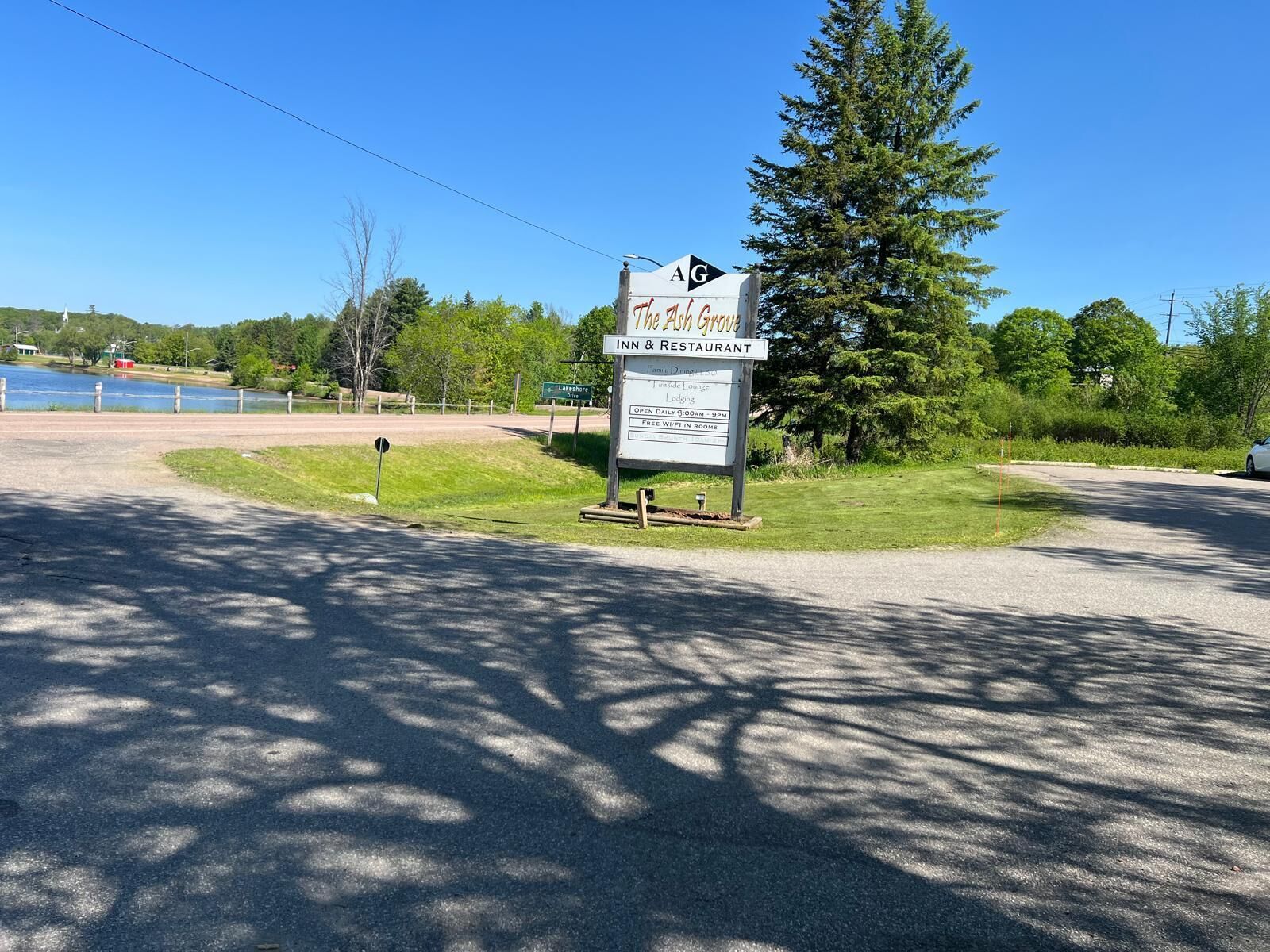 A sign for The Ash Grove Inn & Restaurant with amenities like family dining, indoor lounge, and free WiFi.