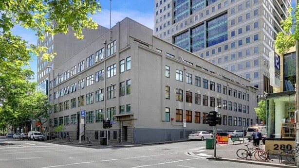 A modern building with a flat facade, large windows, and a parking sign indicating 280. - Spacious 2BR Apartment with Extra Sleeping Space (Melbourne)