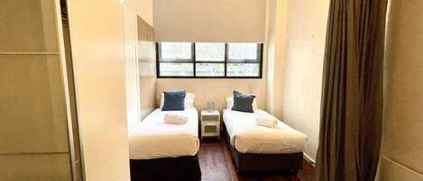 2 habitaciones, escritorio y tabla de planchar con plancha