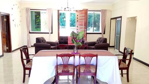 A dining area with a rectangular table, four chairs, and a vase of flowers. - La Costa Villa (Montego Bay)