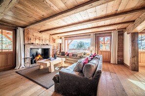 A wooden interior with a fireplace, a sofa, and a wooden ceiling. - Snowcrest - Cosy Apartment in the heart of Verbier (Verbier)