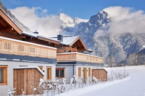A wooden chalet with a balcony, set against a snowy mountain backdrop. - Chalet in Alps Near Ski Lift & Slope (St. Ulrich Am Pillersee)