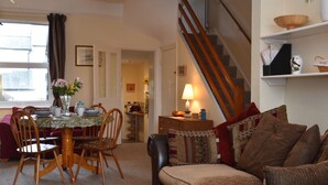 A cozy living room with a dining table, chairs, a sofa, and a staircase. - Tilling View  (Rye)