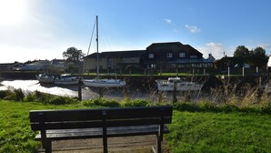 A hotel with a large building and a dock with boats. - Tilling View  (Rye)