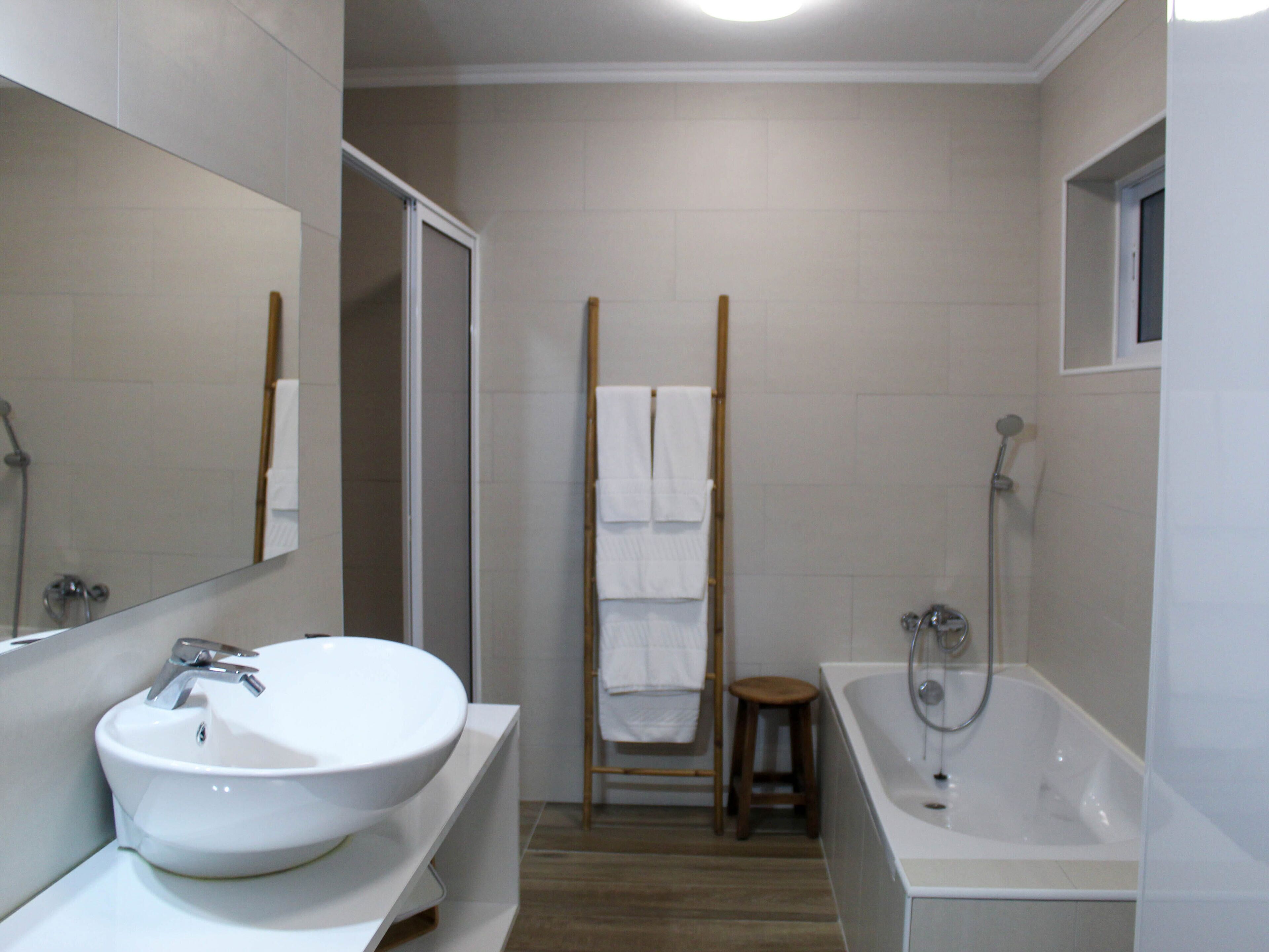 Un baño moderno con un lavamanos grande, una bañera y una ducha.
