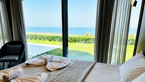 Une chambre d’hôtel avec un lit, des serviettes et une vue sur l’océan.