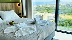 Ein Hotelzimmer mit einem großen Bett, Blick auf die Landschaft und einem Holzkopfende.