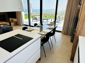 A modern kitchen with a dining area, large windows, and a view of the sea. - Skyline Ocean - 20PL 8BD 6BA, 3min to the beach (GR9M+6V5 Platanias, Greece)