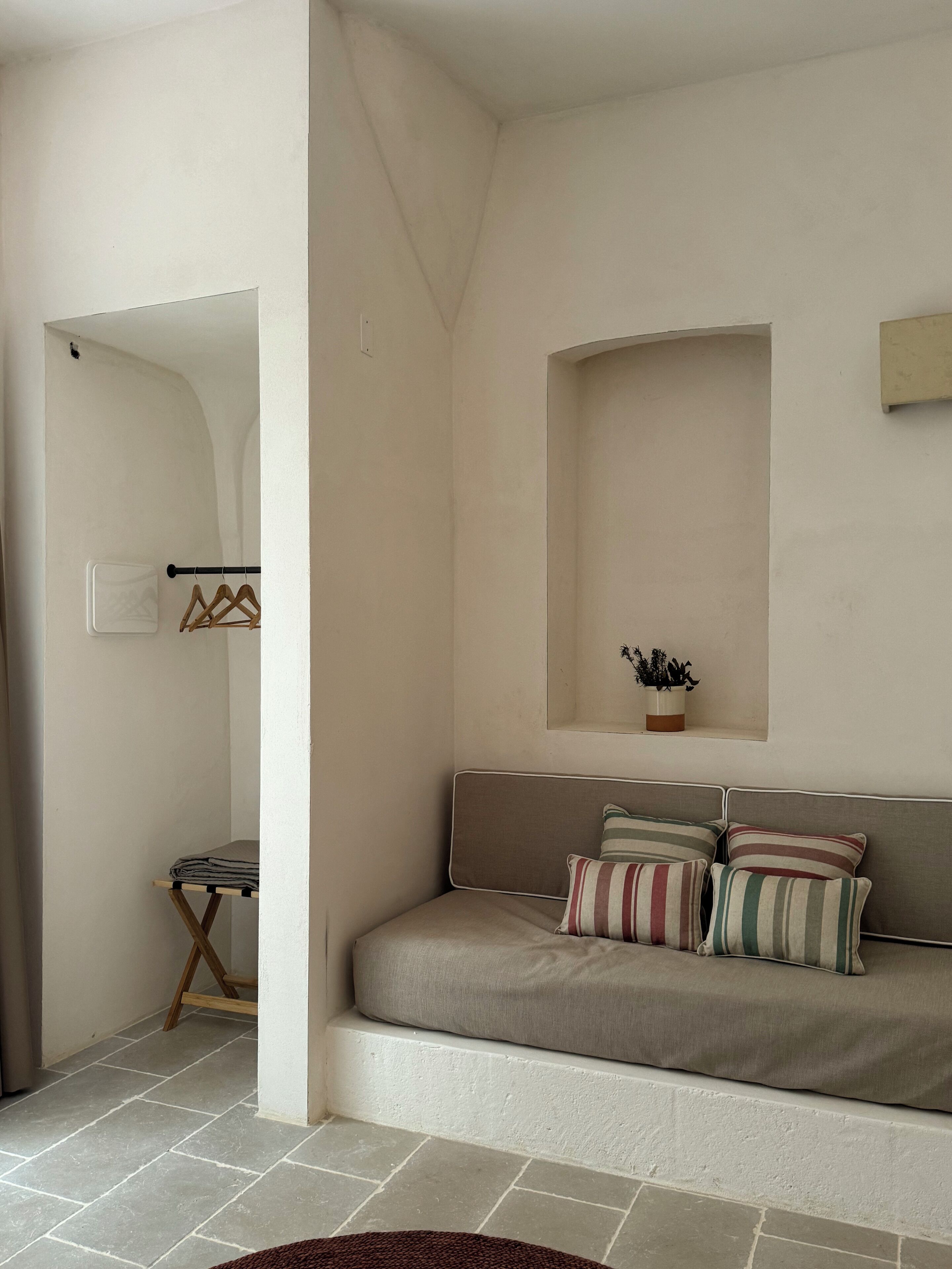A cozy room with a sofa, a small table, and a potted plant.