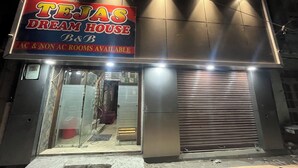 Un edificio con un letrero que dice "TEJAS DREAM HOUSE B&B" y ofrece "HABITACIONES CON Y SIN AIRE ACONDICIONADO".
