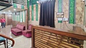 Un área de recepción con un mostrador de madera, un sofá y una escalera.