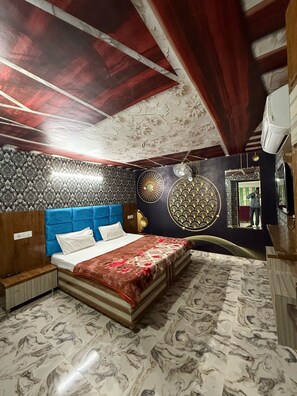 A bedroom with a bed, a vanity, and a mirror.
