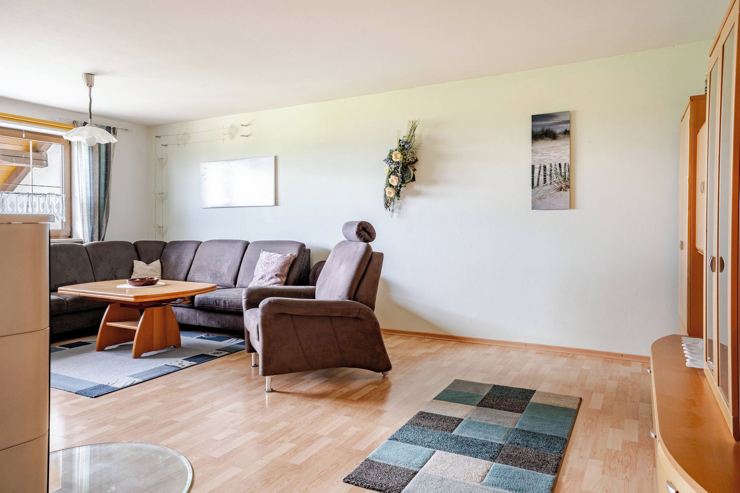 Un salon moderne avec un canapé, une table basse et un tapis.