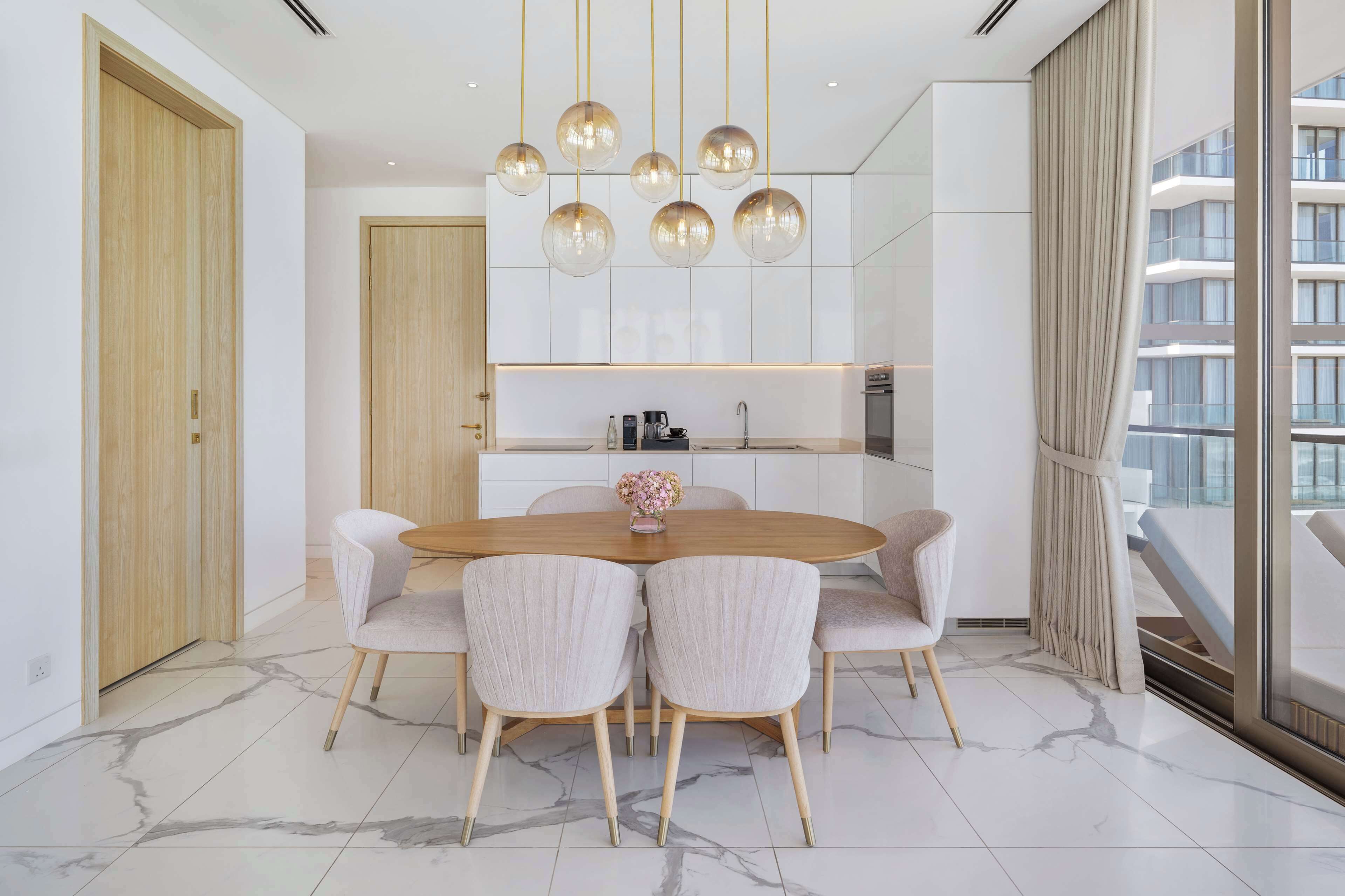 A modern dining area with a marble floor, a wooden dining table, and six upholstered chairs.