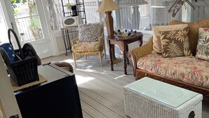 Un salon confortable avec un canapé, un fauteuil, une table et un panier en osier.