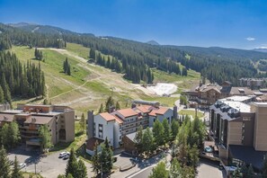 A ski resort with buildings, a parking lot, and a mountainous backdrop. - Copper Junction, Copper Mountain Unit 311 (Frisco)