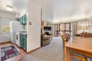 A compact living space with a kitchenette, a dining area, and a seating area with a sofa and chairs. - Copper Junction, Copper Mountain Unit 311 (Frisco)