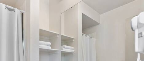 A bathroom with a white toilet, a sink with a mirror above it, and a shower curtain.