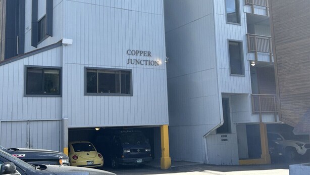 Un edificio con un letrero que dice "Copper Junction" y la entrada a un garaje.
