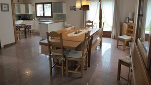 A spacious kitchen with a dining area, wooden furniture, and a view of the outdoors. - House-Comfort-Mountain view-4 etoilles-Mobility bath (Villard De Lans)