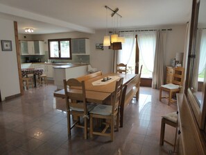 Een ruime keuken met een eethoek, houten meubels en uitzicht op de omgeving.