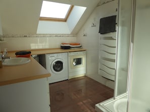 A compact kitchen with a skylight, a washing machine, and a built-in oven. - House-Comfort-Mountain view-4 etoilles-Mobility bath (Villard De Lans)