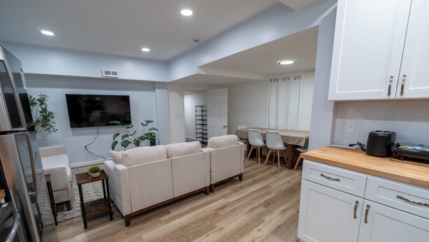 A modern kitchen with white cabinets, a wooden countertop, and a built-in oven. - Spacious and Stylish Apartment Perfect for Your Getaway in Beverly! (Beverly)