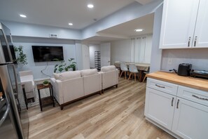 A modern kitchen with white cabinets, a wooden countertop, and a built-in oven. - Spacious and Stylish Apartment Perfect for Your Getaway in Beverly! (Beverly)