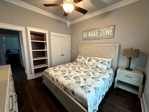 A bedroom with a bed, a nightstand, a ceiling fan, and a wardrobe. - Walk to Beach | Private Pool | Sleeps 8 (Long Beach)