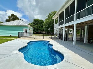 A swimming pool with a curved edge, surrounded by a concrete deck.
