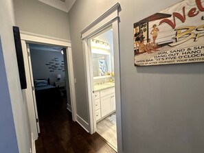 A hallway leading to a bathroom with a sink and mirror. - Walk to Beach | Private Pool | Sleeps 8 (Long Beach)