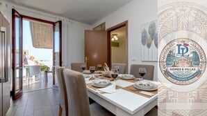 A dining area with a table set for four, including wine glasses and plates.