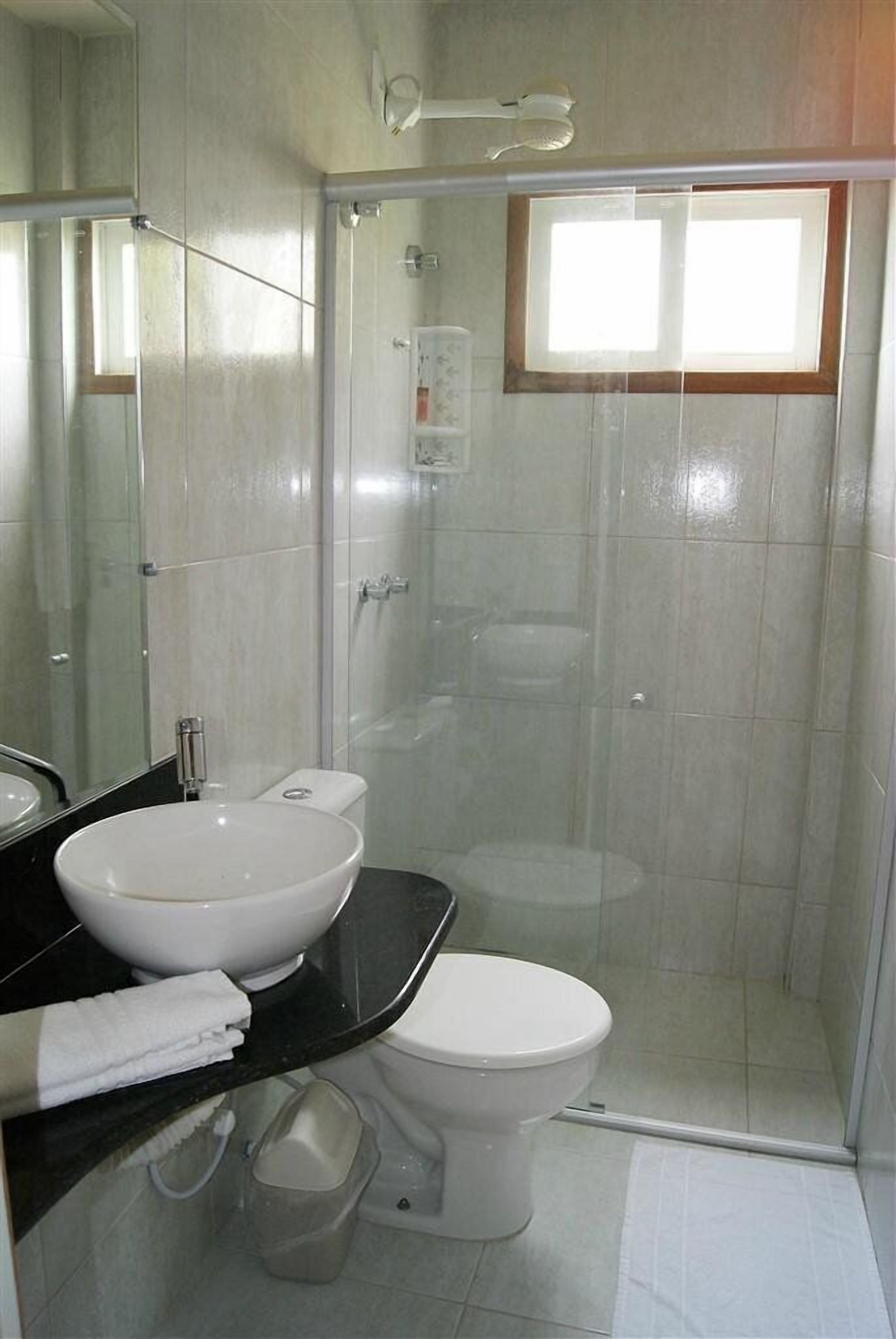 Bañera con ducha, toallas, papel higiénico