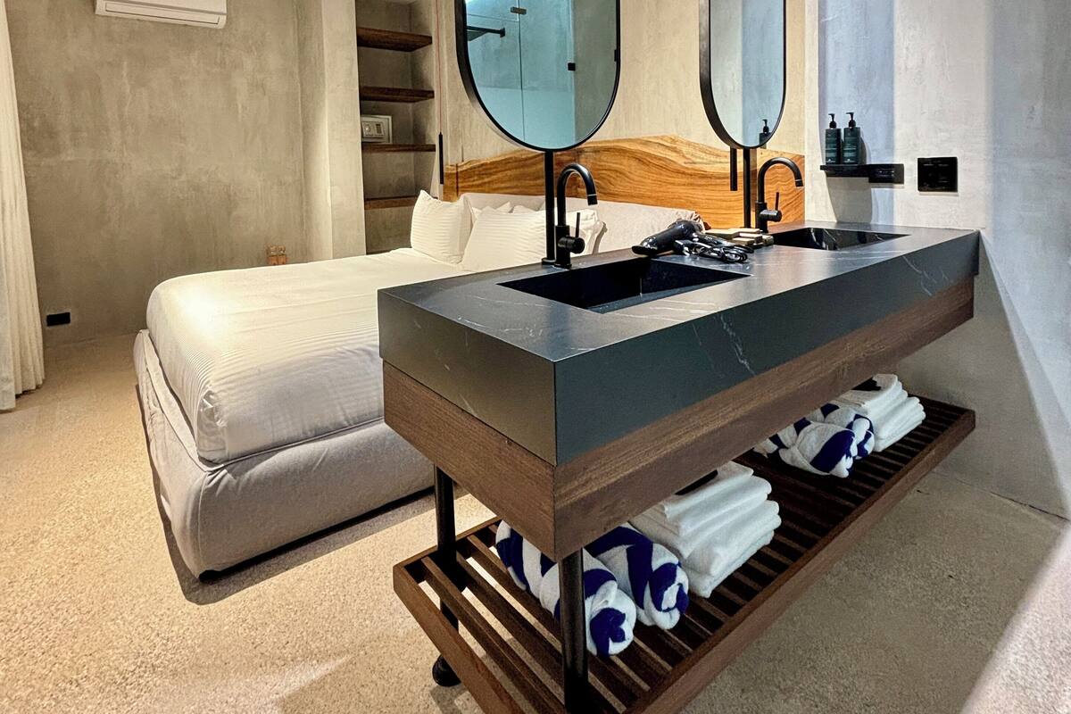 Une salle de bain moderne avec un grand miroir, un lavabo et un porte-serviettes.