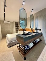 Un baño moderno con un espejo grande, un lavabo y un perchero para toallas.