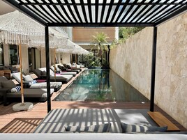 室外游泳池，池畔遮阳伞，日光浴躺椅