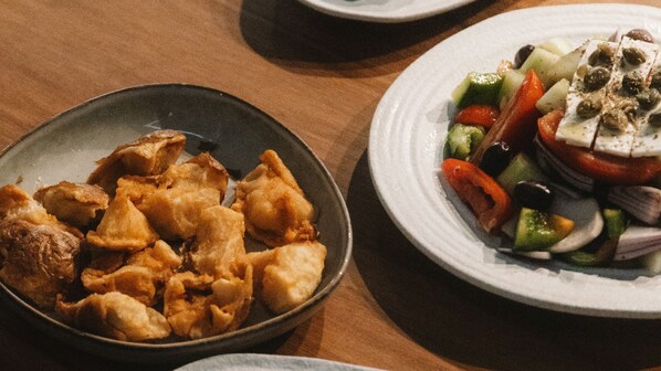 Una mesa con dos platos: uno con comida frita y otro con ensalada.