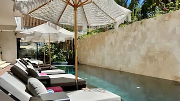 Uma área ao redor da piscina com espreguiçadeiras e guarda-sóis.