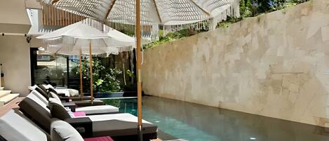A poolside area with lounge chairs and umbrellas.