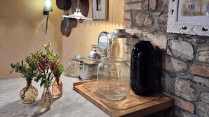 A kitchen with stone walls, hanging pots, a wooden countertop, and a framed picture. - agriturismo il melo rosso   (Fortunago)