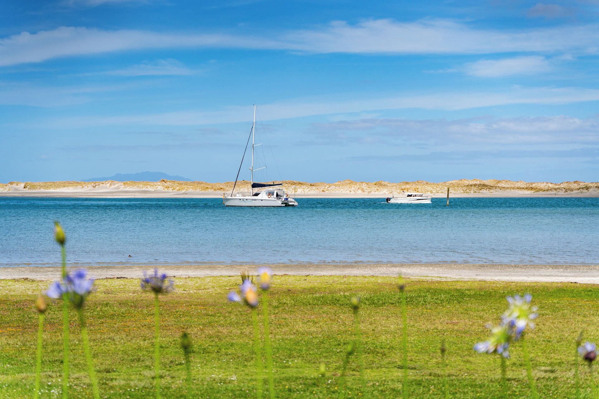 Et roligt hav med to både forankret nær en sandstrand.