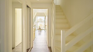 A hallway with a staircase leading to an upper floor. - La plage du Trez - Charmant duplex avec vue mer (Benodet)