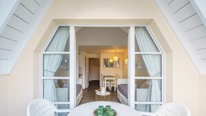 A room with a round table, two white chairs, and a window with curtains. - La plage du Trez - Charmant duplex avec vue mer (Benodet)