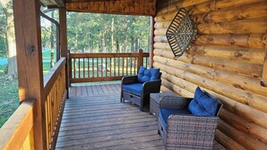 Eine Holzterrasse mit Korbmöbeln und Deckenventilator.