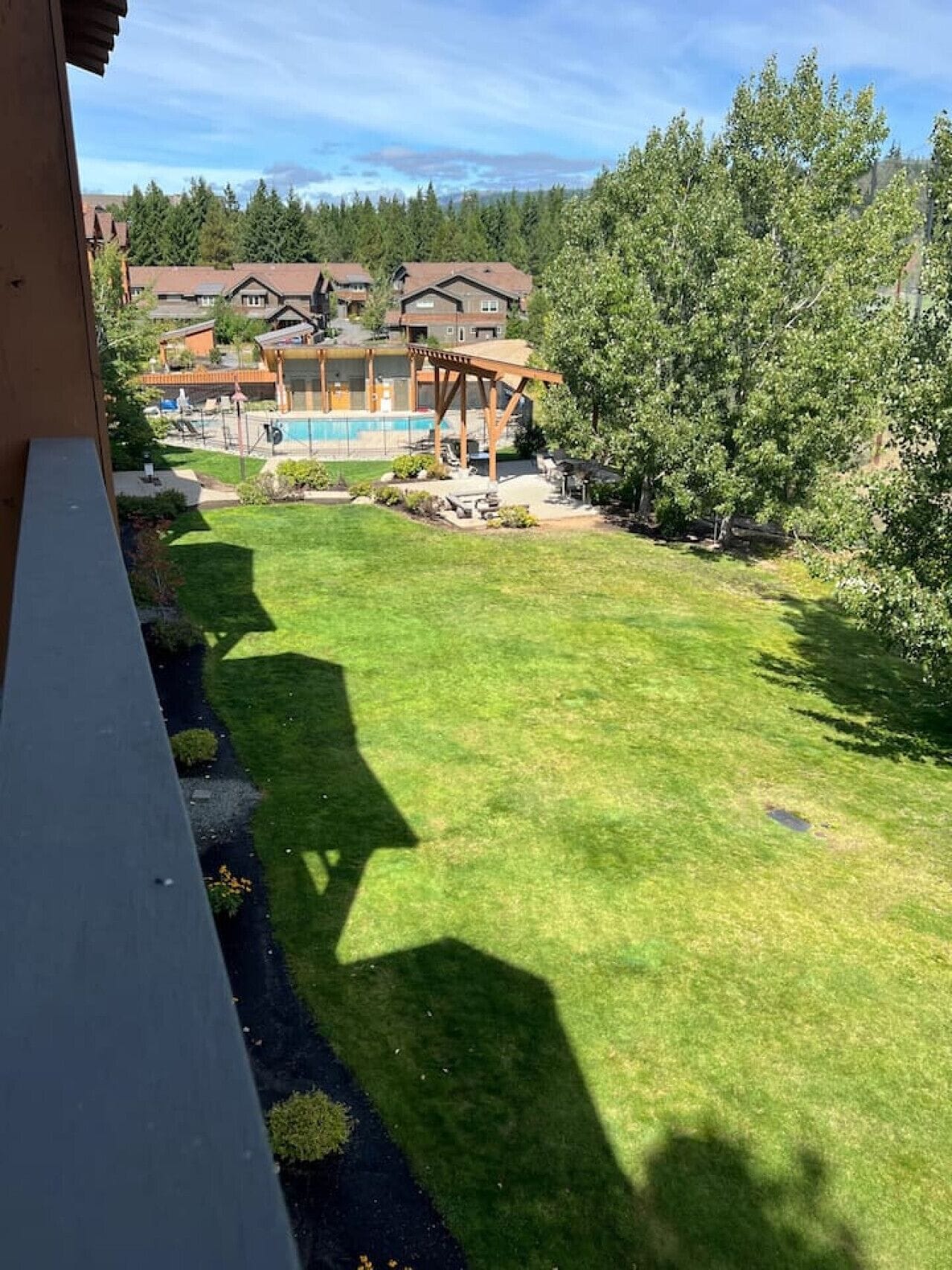 Ein Wohngebiet mit einem gepflegten Rasen, einer Holzpergola und einem Swimmingpool.