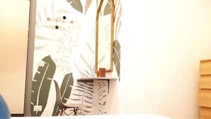 A bathroom with a sink, mirror, and a wall with a leaf pattern.