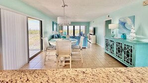 A spacious room with a dining area, a large window, and a view of the outdoors. - Paradise Sea's:  Updated 2B/2B with Ocean View (Cocoa Beach)