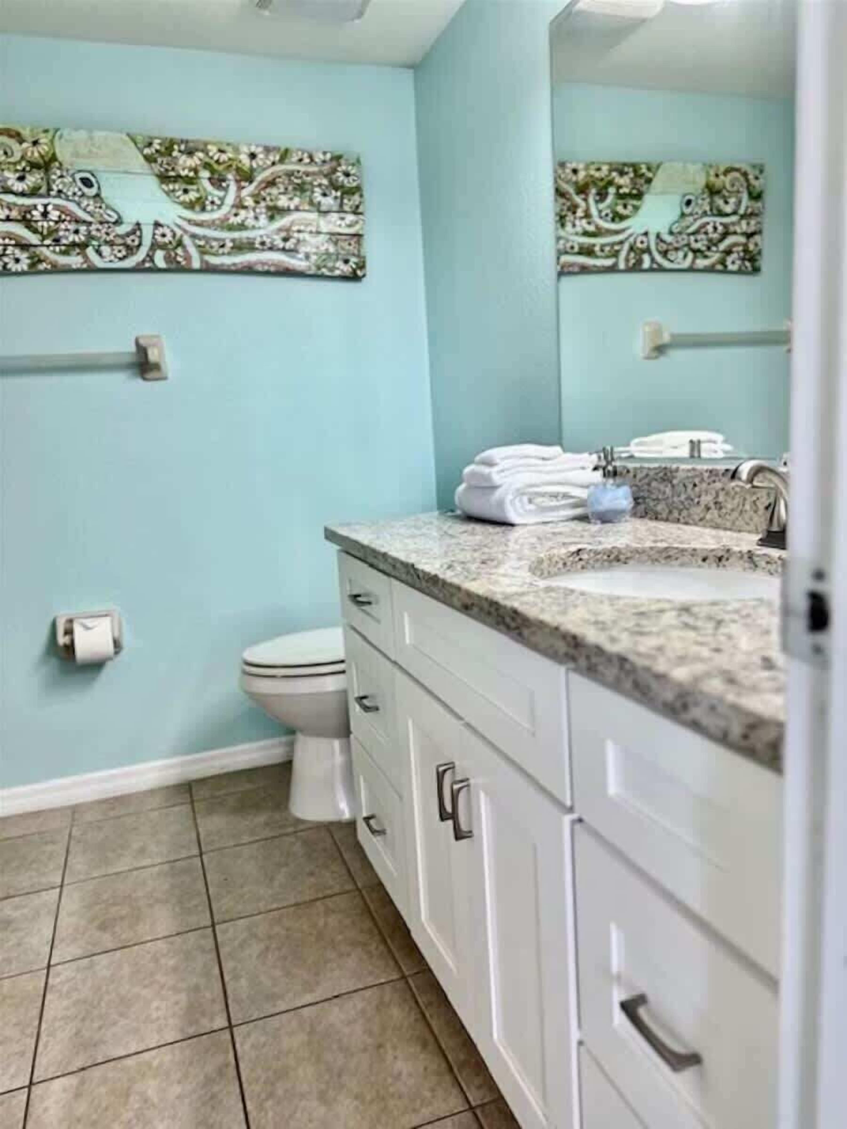 Un baño con inodoro, lavamanos y armarios.