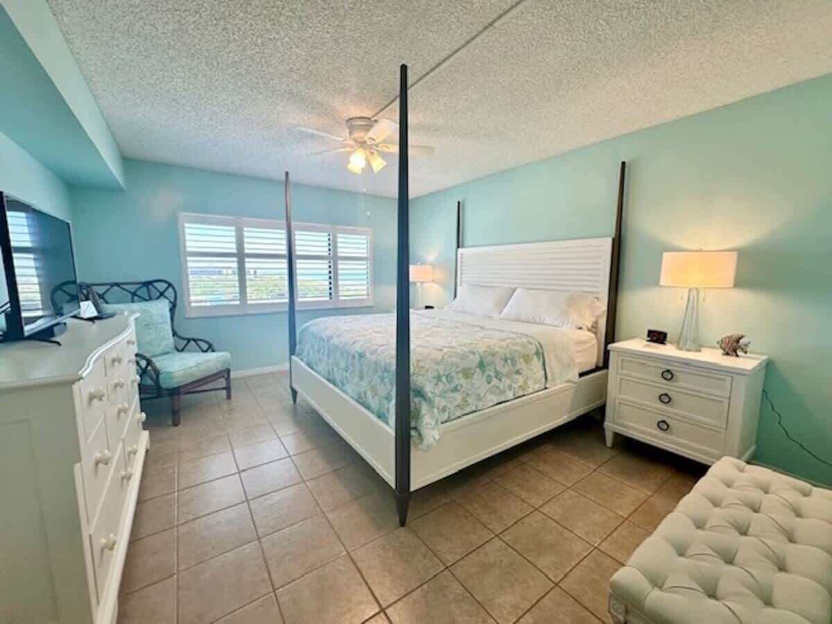 Une chambre à coucher avec un lit à baldaquin, une table de chevet, une commode et une chaise.