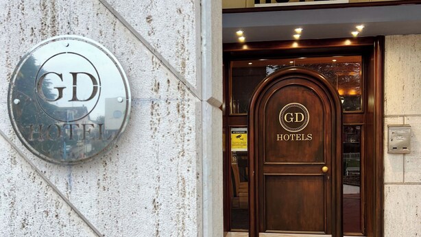 L’entrée d’un hôtel, avec une enseigne indiquant « HÔTEL » au-dessus de la porte.